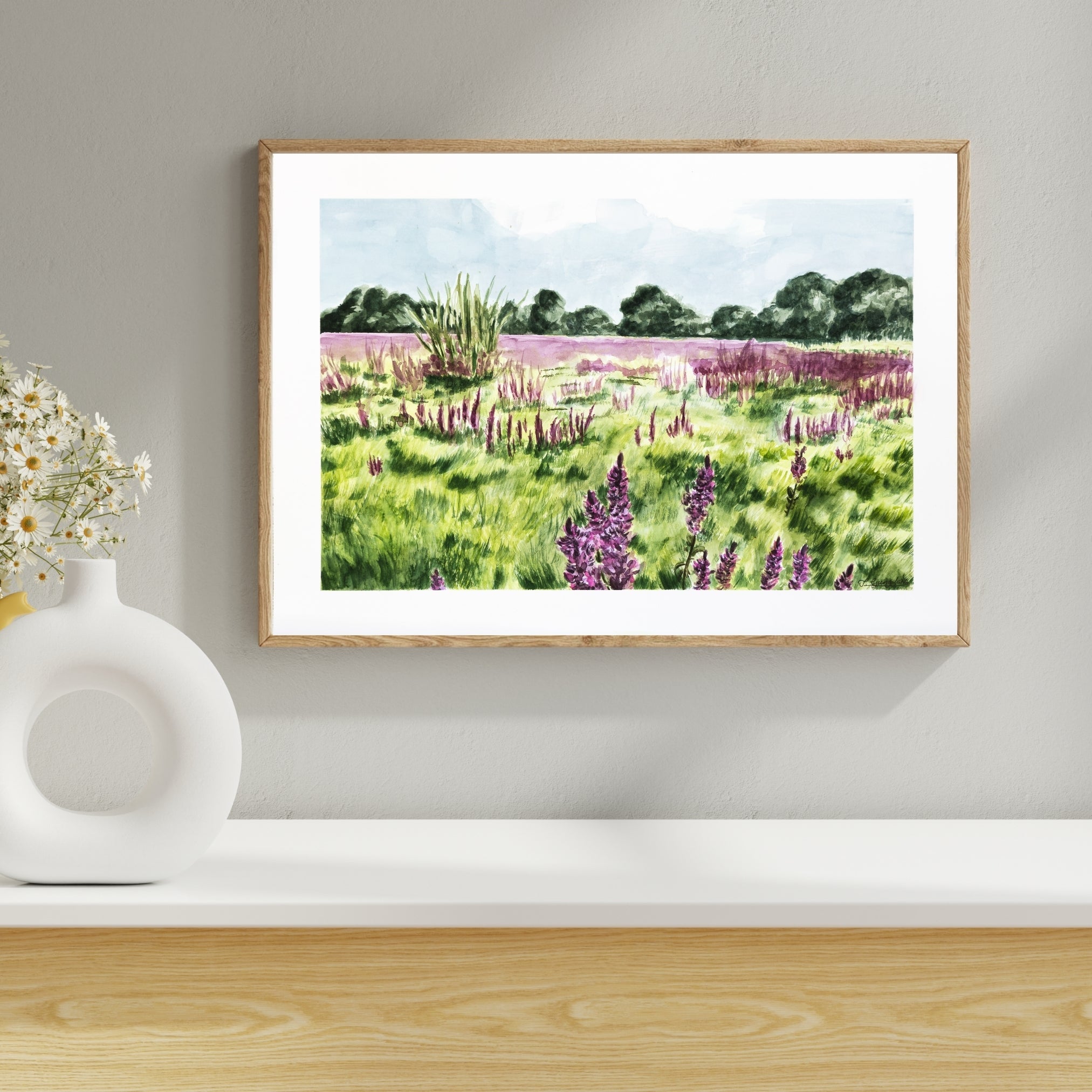 Blomstermark i lys ramme over en hvid hylde med vase